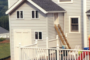 A shed backed up to a home with a play-house for children above