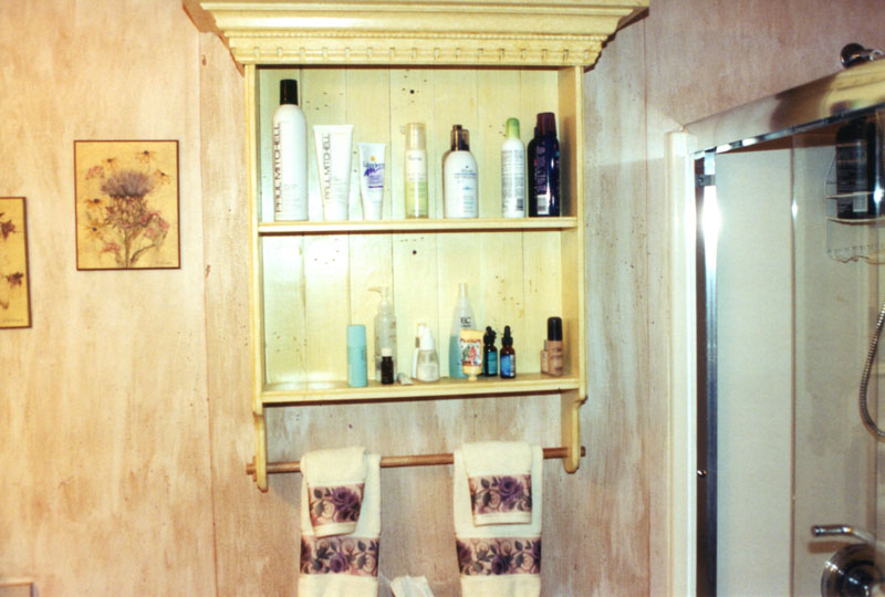 Built-in shelving with crown molding and a towel rack adds value and beauty to this bathroom.